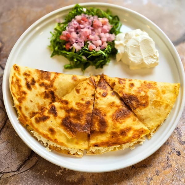 Franco's Taqueria quesadilla with a side of lettuce, pico de gallo, and sour cream.
