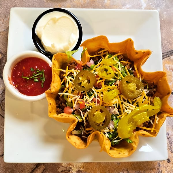 A Franco's Taqueria taco salad in a crispy shell with ground beef, cheese, and jalapeños.
